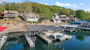 A marina with docked boats, a covered boat launch ramp, and houses in the background. - Family-friendly, Dock Enjoyment, Kayaks, Lake View (Sunrise Beach)