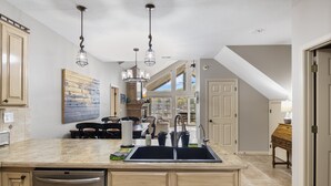 A kitchen with a large island, double sink, and overhead pendant lighting. - Family-friendly, Dock Enjoyment, Kayaks, Lake View (Sunrise Beach)