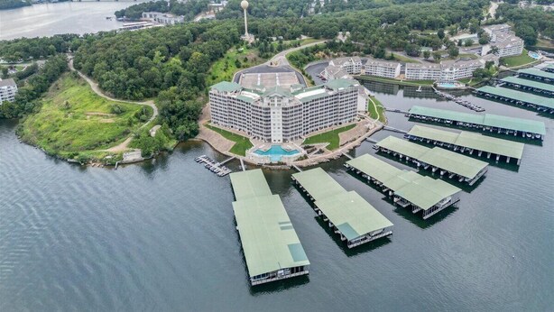Um hotel grande com um edifício central rodeado por água e barcos atracados.