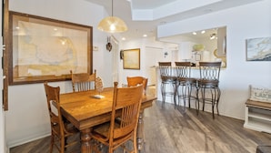 A dining area with a wooden table and chairs, a hanging light fixture, and a framed map on the wall. - Prime Spot, Breathtaking Views, Nearby Attractions (Lake Ozark)