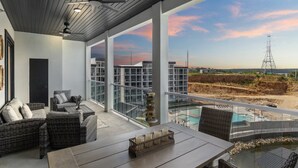 Un espace extérieur aménagé de façon moderne, avec des meubles en osier et une vue sur un chantier de construction.