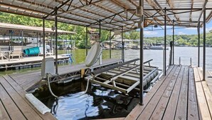 A covered dock with a swimming pool, wooden deck, and a view of the water and surrounding buildings. - Pet Friendly A Frame w/ Private Dock & Great Lake Views (Rocky Mount)