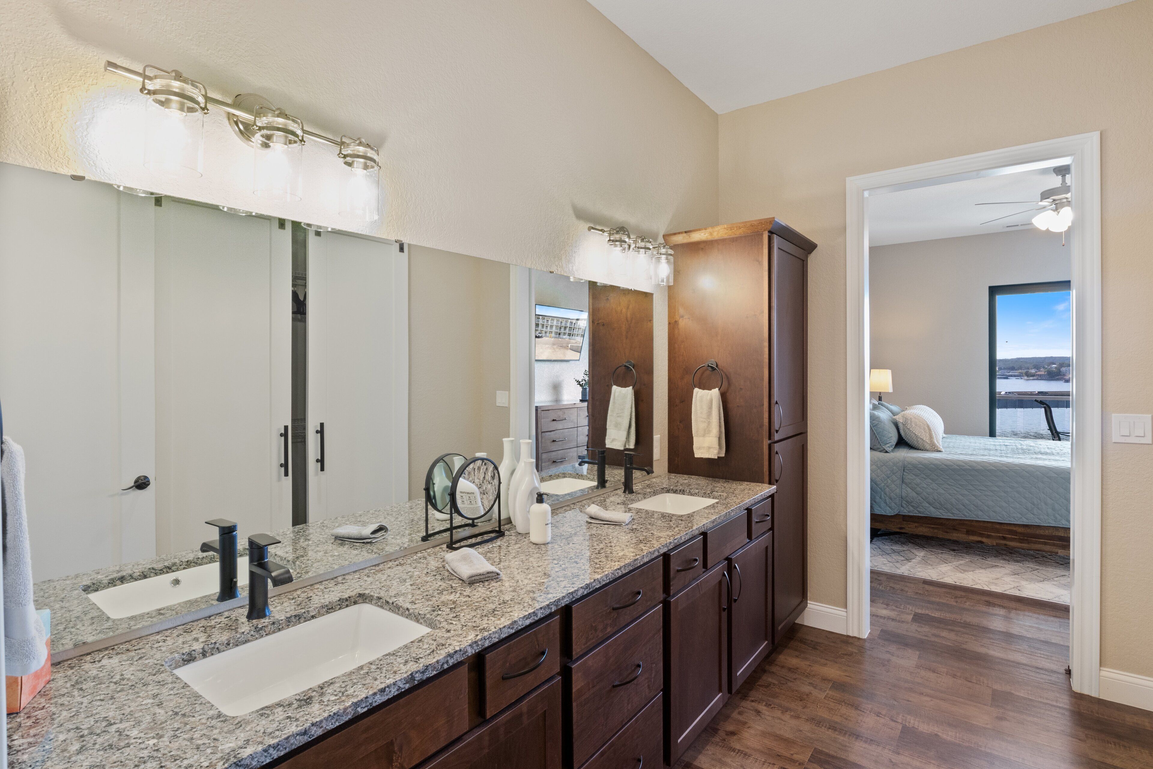 A bathroom with two sinks, a large mirror, and a vanity with drawers.