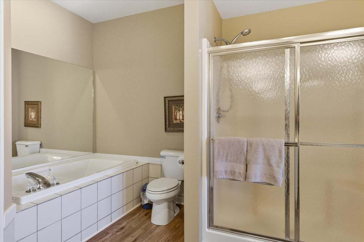 A bathroom with a bathtub, toilet, and shower.
