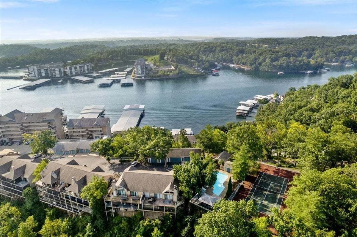 A coastal hotel with multiple buildings, a swimming pool, and boats on the water.