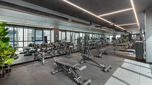 A modern gym with various exercise equipment, large windows, and a clean, well-lit interior. - 2-bed Inner-city Pad With Pool, (Melbourne)