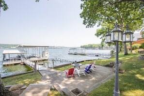 Une terrasse au bord du lac, avec des sièges d’extérieur, un quai et un lampadaire.