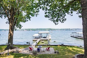 Une terrasse au bord du lac, avec des sièges d’extérieur, un espace couvert et une jetée qui s’avance dans l’eau.