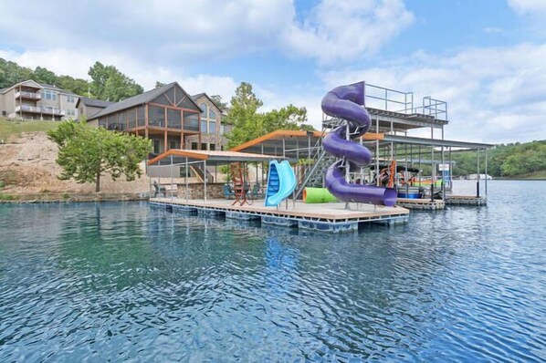 Un parco acquatico con uno scivolo gigante, una piscina e un edificio con facciata in vetro.