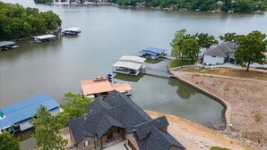Une propriété au bord du lac, dotée d’un quai, de bateaux et d’une maison avec un garage.
