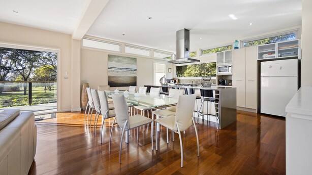 A modern kitchen with a dining area, large windows, and a view of the outdoors. - Spacious 3-bed Townhouse Near Dromana Beach (Melbourne)