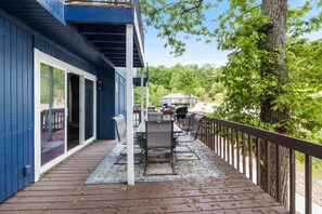 Una terraza con mobiliario exterior y vista a una casa al fondo.
