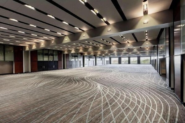 A spacious conference room with a patterned carpet, large windows, and modern lighting fixtures. - Hilton Mexico City Reforma (Mexico City)