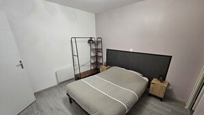 A bedroom with a bed, a wardrobe, a bedside table, and a nightstand. - Apartment in the immediate vicinity of Château de Maintenon (Pierres)