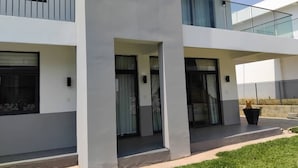Un immeuble moderne à plusieurs étages, doté de balcons, de grandes fenêtres et d’un toit plat.