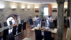 A restaurant with stone walls, multiple tables, and chairs. - Comfort Double Room with Free Parking (Schlitz)