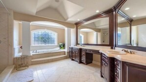 A spacious bathroom with a large vanity, a walk-in shower, and a window providing natural light. - Vancouver Red House (Coquitlam)