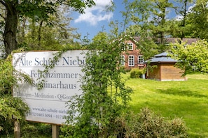 Skilt for Alte Schule Nieburg, der angiver et kursussted med massage, meditation og Qi Gong.