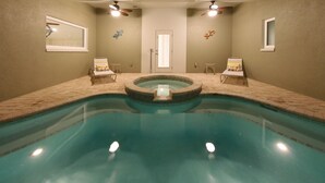 Una piscina con dos sillas de descanso y un jacuzzi.