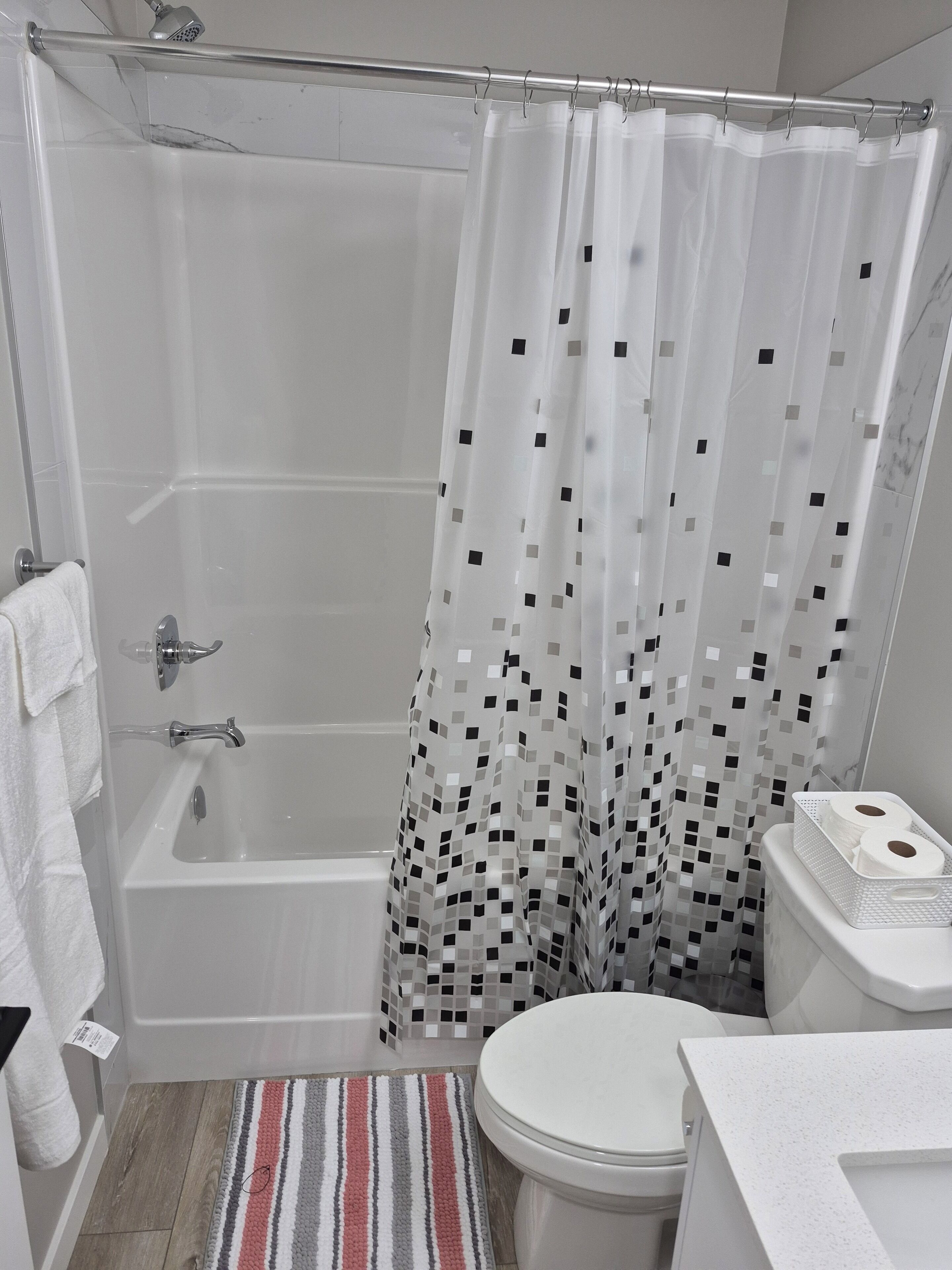 A bathroom with a shower, toilet, and a small sink.
