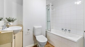 A bathroom with a toilet, sink, and bathtub. - Chic 2-bed Apartment Near Albert Park (Melbourne)