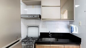 Une cuisine équipée d’une cuisinière à gaz, d’un évier et d’une machine à café.