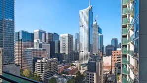 Un paysage urbain avec des immeubles modernes de grande hauteur, dont un gratte-ciel à la forme incurvée remarquable.