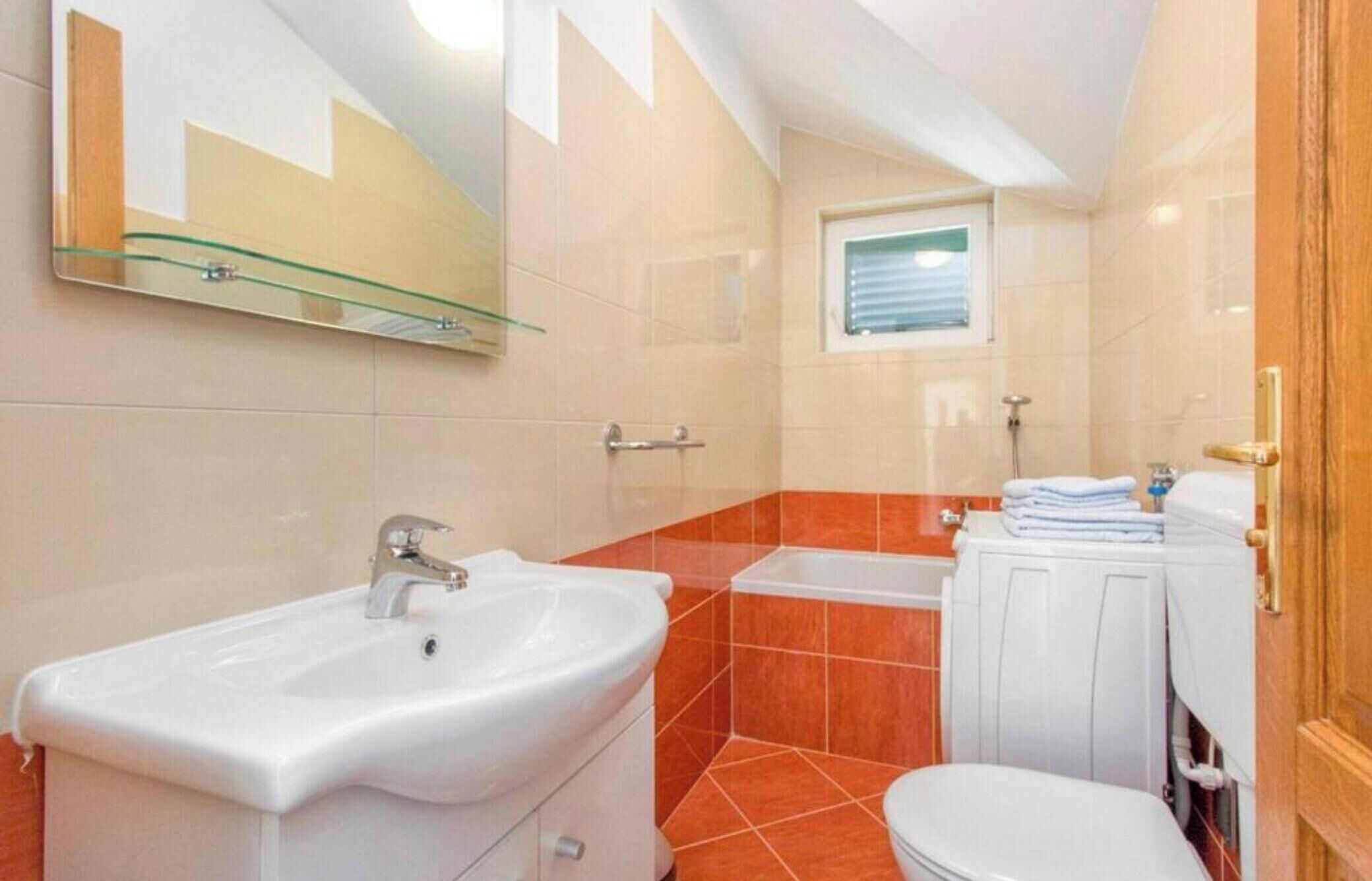 A bathroom with a white sink, a toilet, and a bathtub.