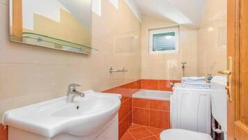 A bathroom with a white sink, a toilet, and a bathtub.