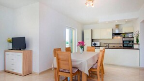 A modern kitchen with white cabinets, a microwave, and an oven. - Villa Dalmacija (Drnis)
