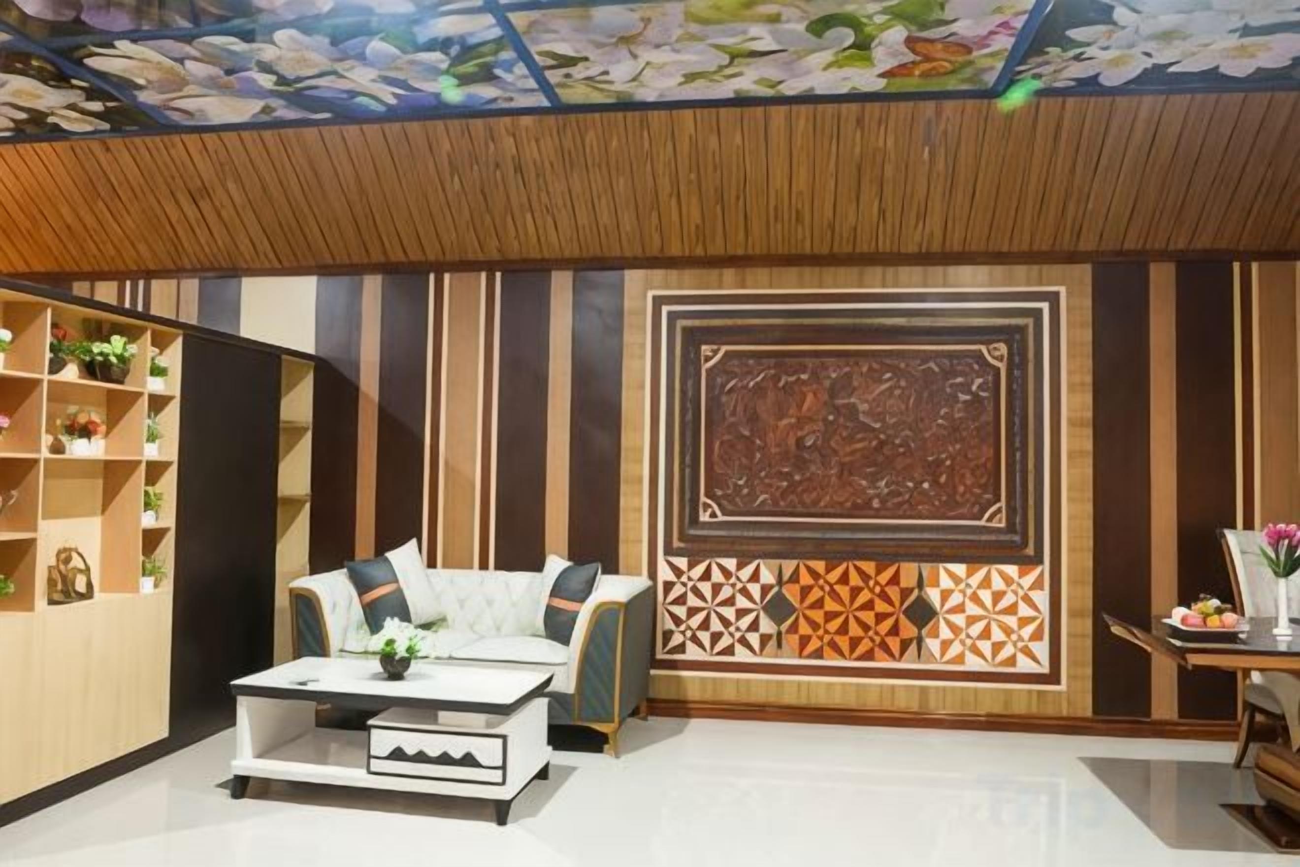 A room with a sofa, a coffee table, a decorative wall panel, and a ceiling with a floral pattern.