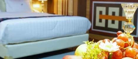 Una habitación de hotel con una cama, una mesita de noche con lámpara y un adorno en la pared.