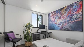 A modern bedroom with a bed, a desk, a chair, a large window, and a vibrant abstract painting. - Bright City-view Retreat in the Heart of Preston (Melbourne)
