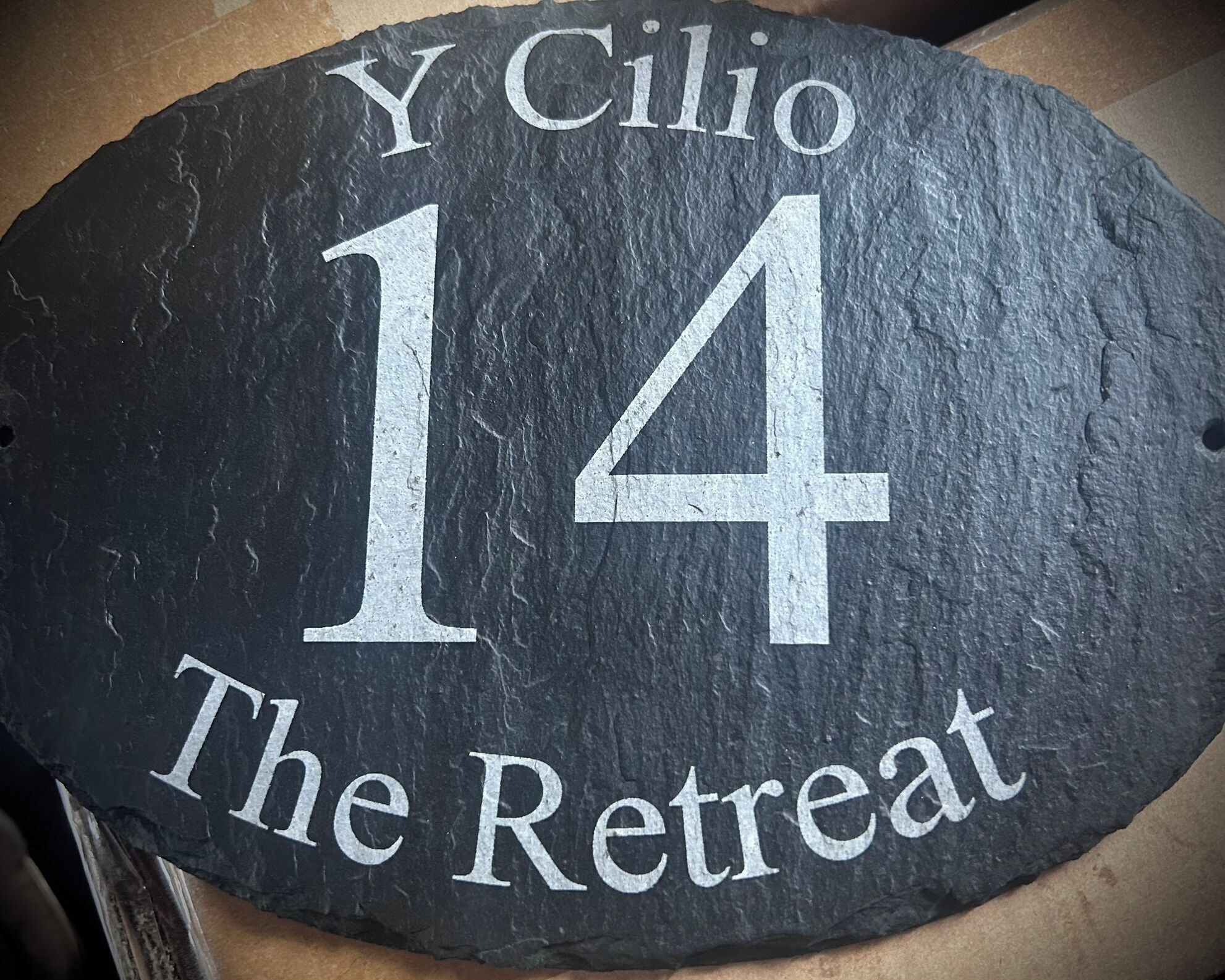 Un letrero de pizarra que dice "Y Cilio 14 The Retreat".