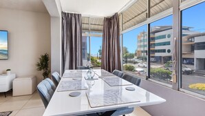 Une salle de conférence moderne, dotée d’une longue table, de sièges confortables, de grandes fenêtres et offrant une vue sur la ville.