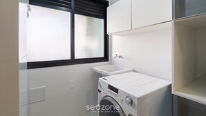 A laundry room with a washing machine, a sink, and a window with blinds. - 2 Bed. Apt 300 m From the Beira-mar Norte Evp0214 (Florianópolis)