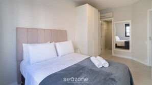 A bedroom with a bed, a wardrobe, and a mirror. - 2 Bed. Apt 300 m From the Beira-mar Norte Evp0214 (Florianópolis)