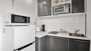 Eine moderne Küche mit einem weißen Kühlschrank, einer Mikrowelle, einem Toaster und einem Spülbecken.