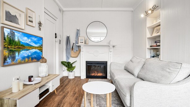 Ein modernes Wohnzimmer mit Kamin, einem großen Gemälde und einer gemütlichen Sitzecke.