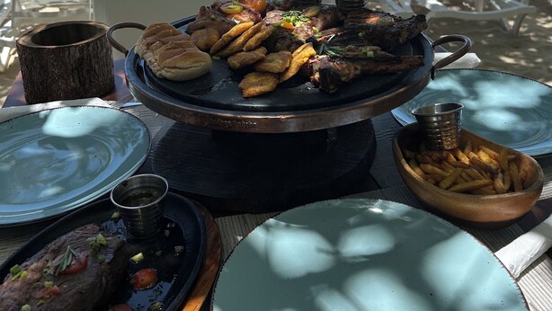 A beachside dining setup with a grill, plates, and chairs. - Fantastic apartment with AC in Green one, Playa Dorada (Playa dorada)