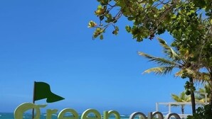A sign for 'Green One Playa Dorada' with a clear view of the beach and ocean in the background. - Fantastic apartment with AC in Green one, Playa Dorada (Playa dorada)