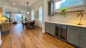A modern kitchen with wooden flooring, grey cabinets, and a large window. - Grant Park Retreat - Steps to Zoo, & Great Eats (Atlanta)