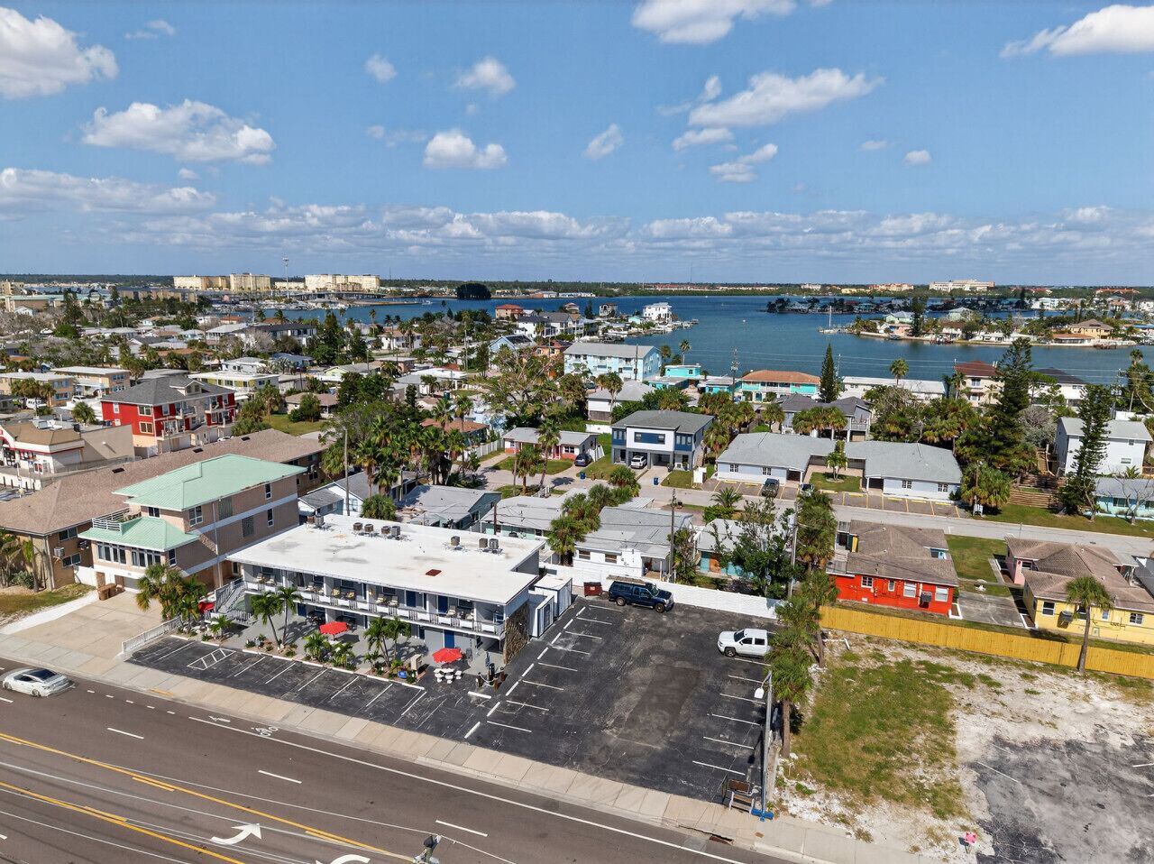 An aerial view of a coastal town with buildings, a marina, and a large body of water.