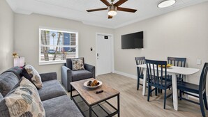 Una sala moderna con sofá, sillón y mesa de comedor.