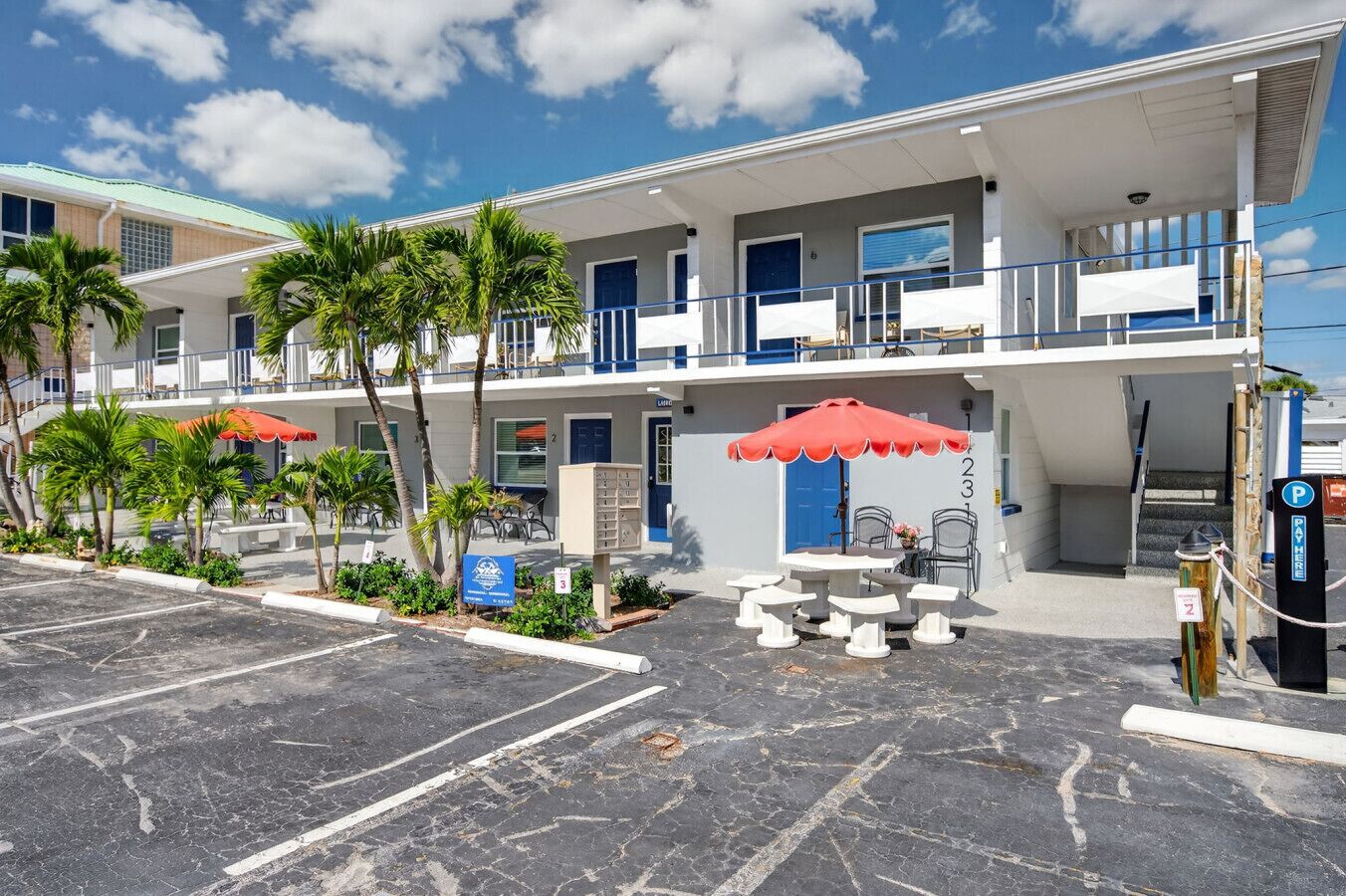 A two-story motel with outdoor seating and a parking area.