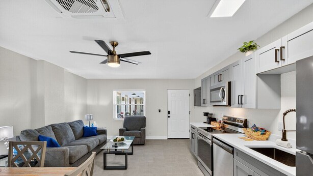 A modern apartment with a living room, kitchen, and dining area.