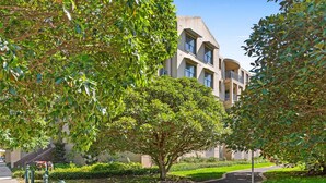 A building with a modern architectural style, surrounded by lush greenery and a well-maintained garden. - Elegant Stay in Balmain With Pool Access (Sydney)