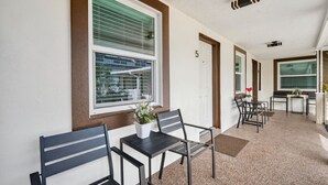 A corridor with a seating area featuring a table and chairs, a door marked with the number 5, and a window with blinds. - 🌴 Updated1BR at Park Shore Suites | Steps to Madeira Beach | Courtyard & Grill 🌅 (Madeira Beach)