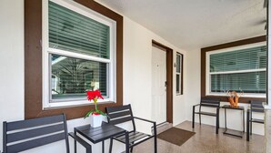 A clean, modern hallway with two black chairs and a small table, a potted plant, and a decorative vase on a small table. - Modern 2BR at Park Shore Suites | Walk to Madeira Beach | Courtyard & Grill (Madeira Beach)