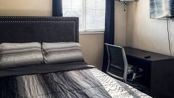 Tabla de planchar con plancha, internet y ropa de cama